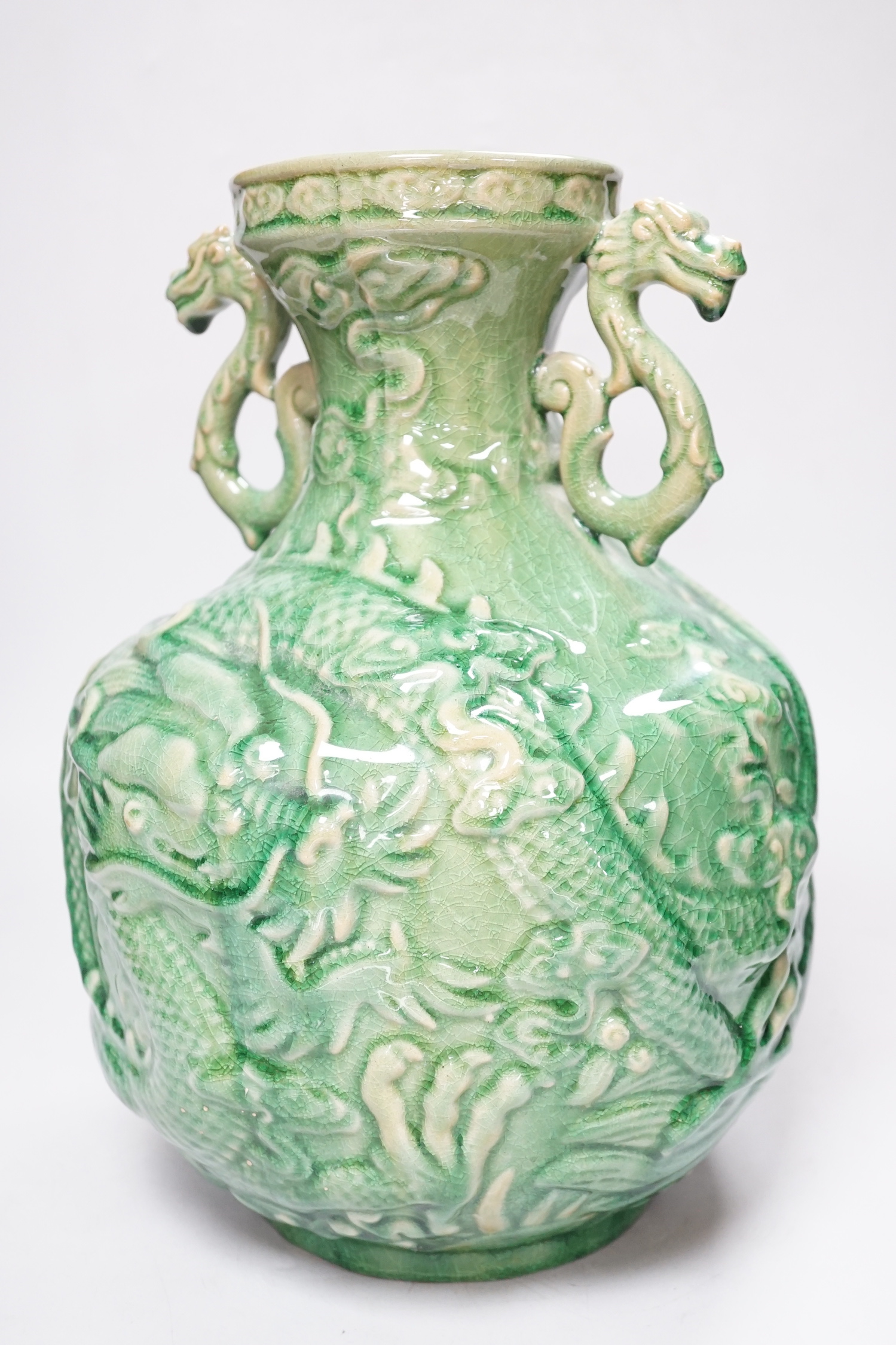 A Chinese green glazed vase with twin zoomorphic handles, decorated in relief with dragons, 35cm high